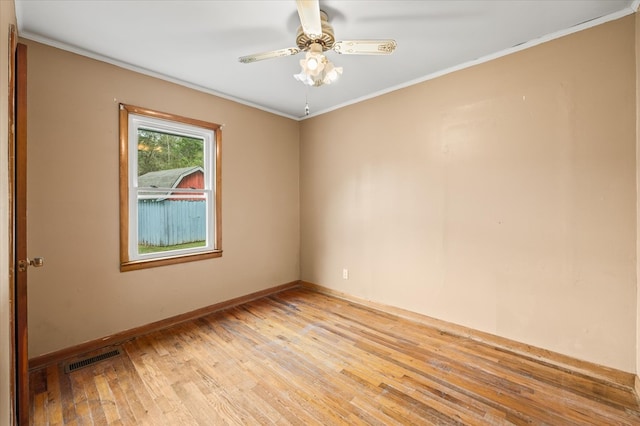 spare room with visible vents, baseboards, light wood-style flooring, ceiling fan, and crown molding