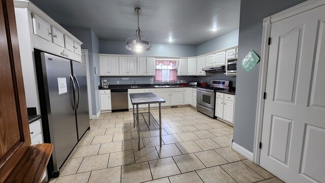 kitchen featuring stainless steel appliances, dark countertops, and white cabinetry