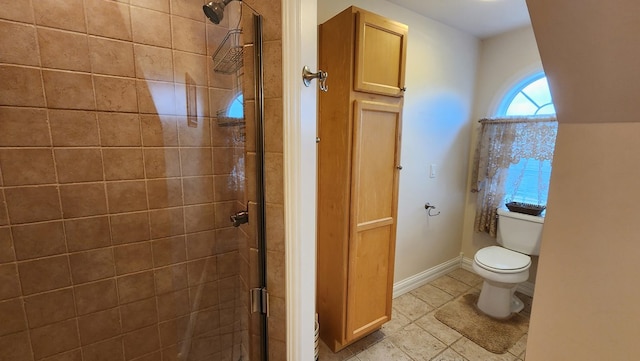 bathroom with a stall shower, tile patterned floors, toilet, and baseboards