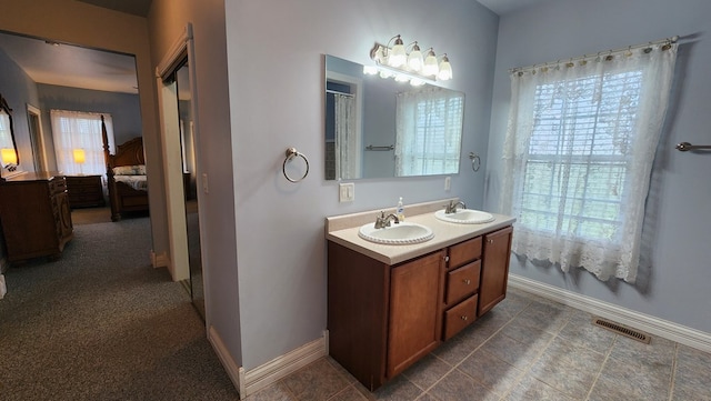 ensuite bathroom featuring plenty of natural light, visible vents, a sink, and ensuite bathroom