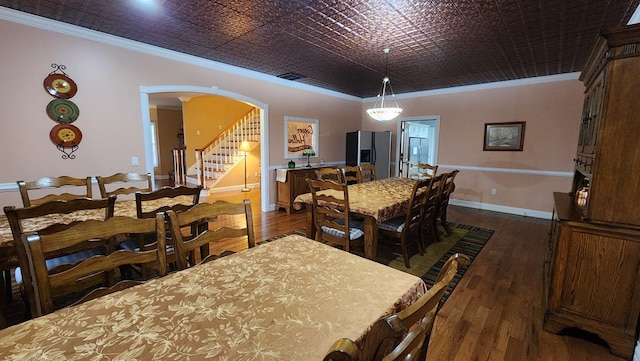 dining room featuring arched walkways, baseboards, ornamental molding, stairway, and an ornate ceiling