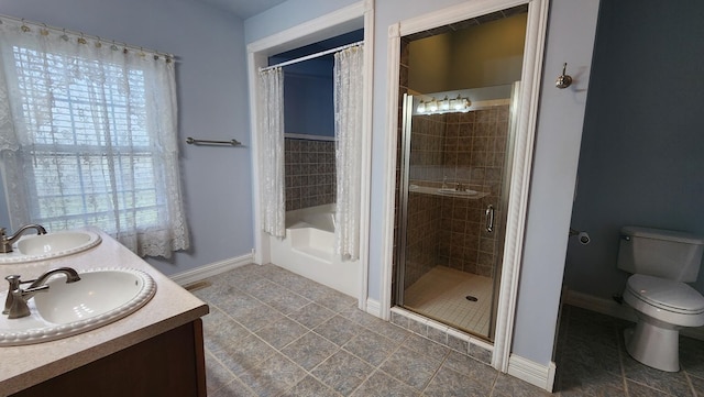 full bathroom with a bath, double vanity, a sink, and toilet