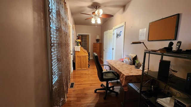 home office featuring a ceiling fan, visible vents, and wood finished floors