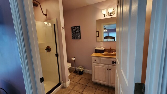 bathroom featuring a stall shower, baseboards, toilet, tile patterned floors, and vanity