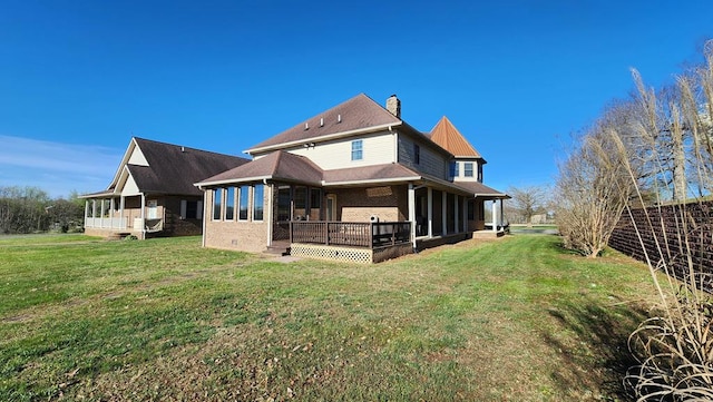 back of property with crawl space, brick siding, a chimney, and a yard