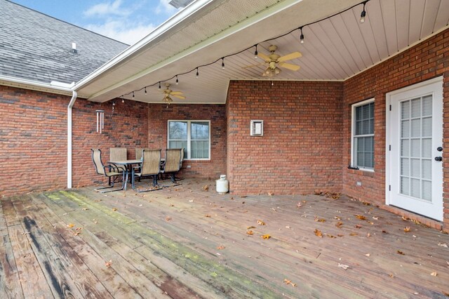 wooden terrace with outdoor dining area and ceiling fan