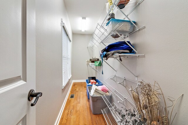 walk in closet with visible vents and wood finished floors