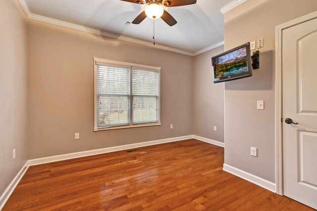 empty room featuring baseboards, wood finished floors, a ceiling fan, and crown molding