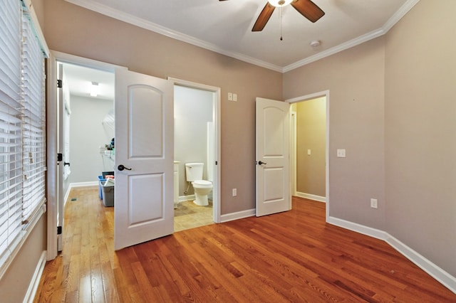 unfurnished bedroom featuring baseboards, hardwood / wood-style flooring, ensuite bath, ceiling fan, and ornamental molding