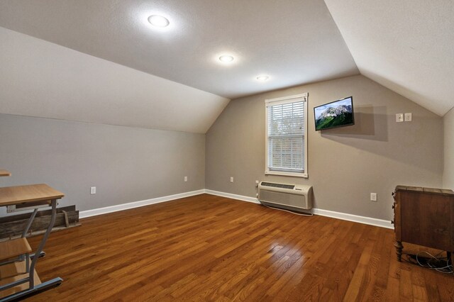 additional living space featuring vaulted ceiling, wood-type flooring, and baseboards