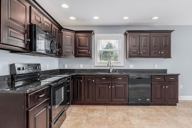 kitchen featuring dark stone countertops, dark brown cabinets, black appliances, a sink, and recessed lighting