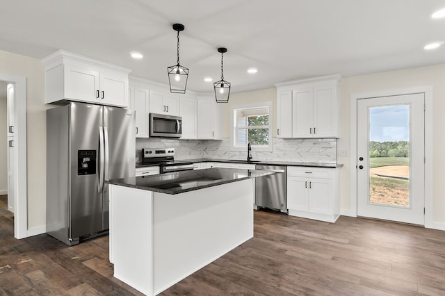 kitchen with pendant lighting, appliances with stainless steel finishes, white cabinets, and a center island