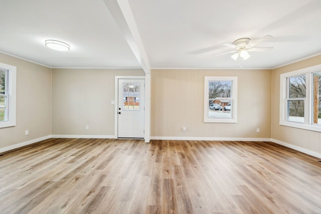 empty room with light wood-type flooring, ceiling fan, baseboards, and crown molding