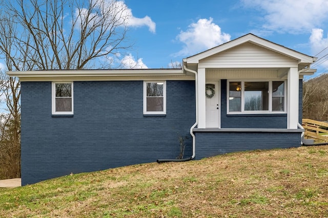 view of front facade with a front lawn and brick siding