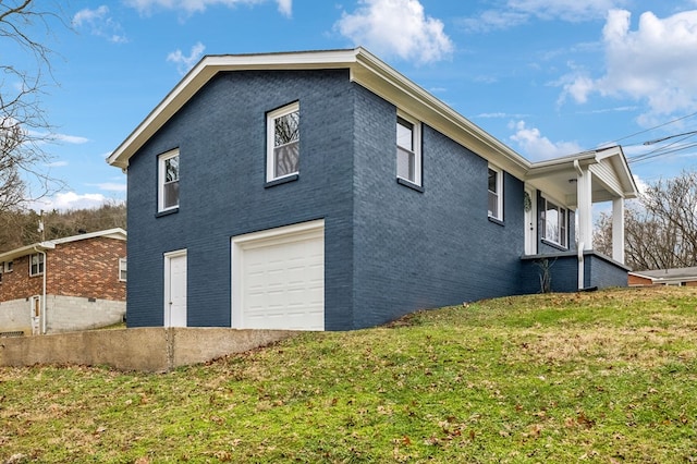 view of home's exterior featuring brick siding, a yard, and an attached garage