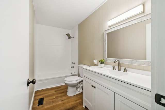 full bath featuring shower / washtub combination, visible vents, toilet, vanity, and wood finished floors