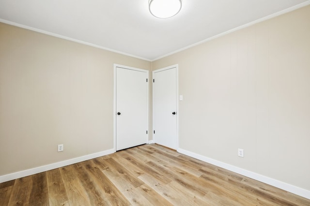 unfurnished room featuring light wood finished floors, baseboards, and ornamental molding