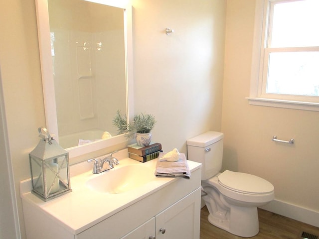 full bath with visible vents, toilet, wood finished floors, baseboards, and vanity