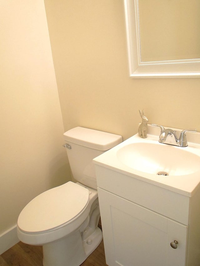 bathroom with toilet, wood finished floors, and vanity