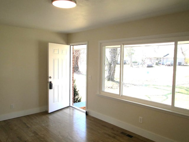 spare room with wood finished floors, baseboards, and visible vents