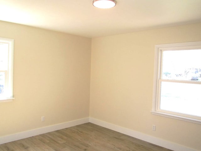 empty room with baseboards and wood finished floors