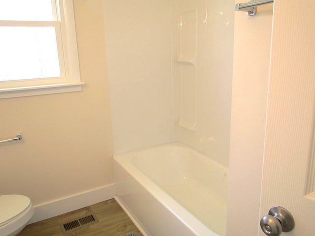 bathroom featuring wood finished floors, toilet, baseboards, and visible vents