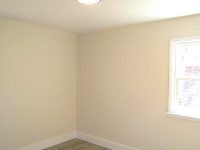 spare room featuring wood finished floors and baseboards