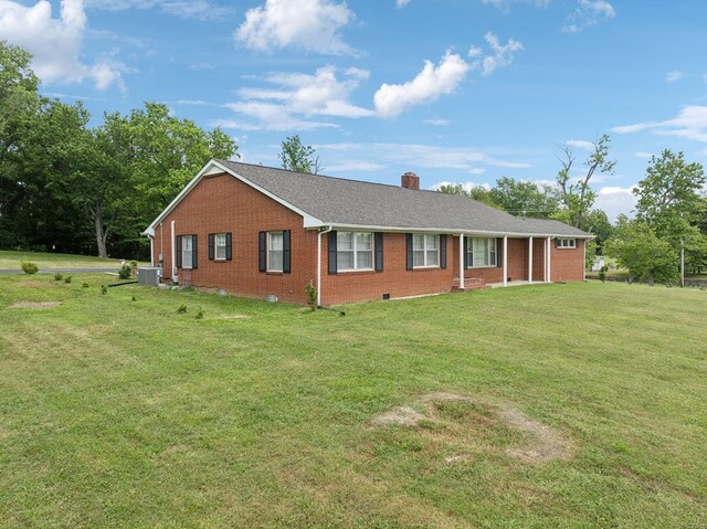 ranch-style home featuring brick siding, roof with shingles, a chimney, a front yard, and crawl space