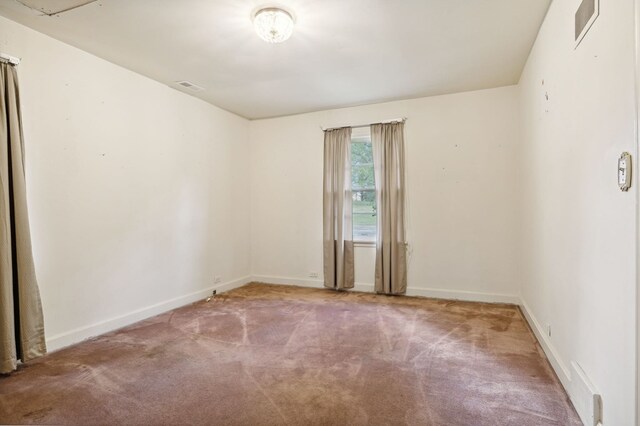 unfurnished room with carpet, visible vents, and baseboards