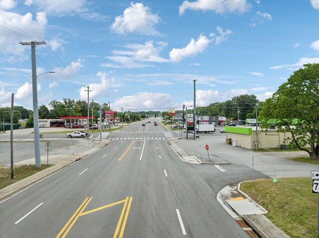 view of street with sidewalks, street lights, and curbs