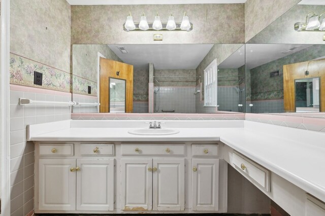 bathroom featuring tile walls, a shower stall, and vanity