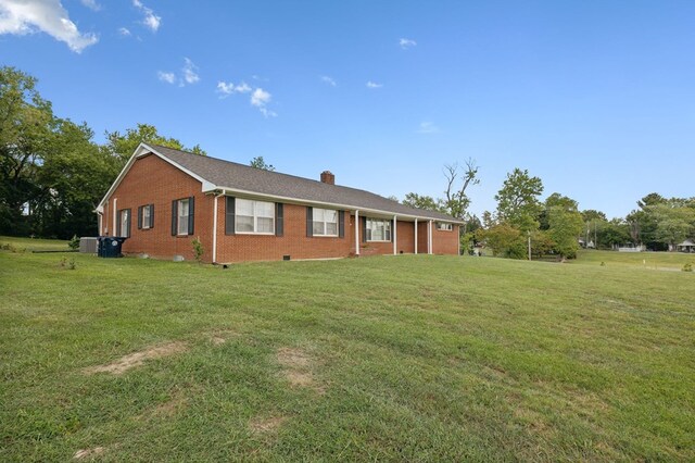 exterior space with brick siding, a front lawn, and a chimney