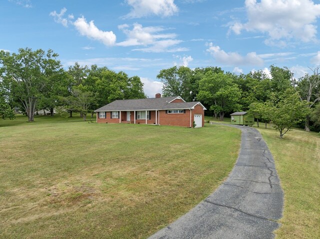 ranch-style house with a front yard, brick siding, driveway, and an attached garage