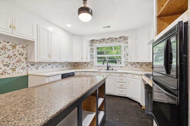 kitchen with white cabinets, a sink, visible vents, and open shelves