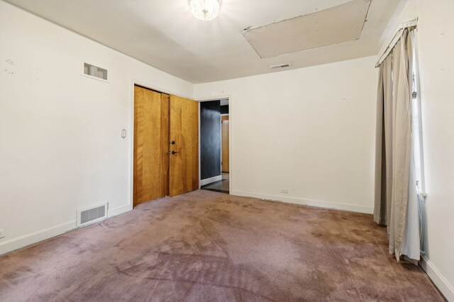 unfurnished bedroom featuring carpet flooring, visible vents, and baseboards