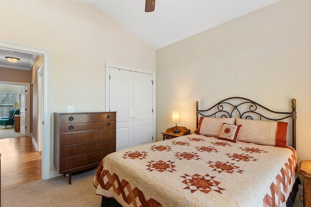 carpeted bedroom with a closet, baseboards, high vaulted ceiling, and a ceiling fan