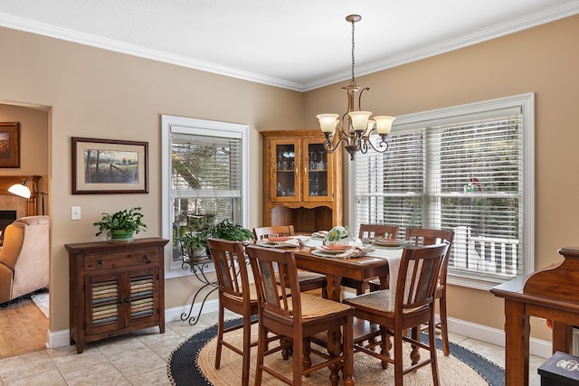 dining room with a chandelier, light tile patterned flooring, baseboards, and ornamental molding