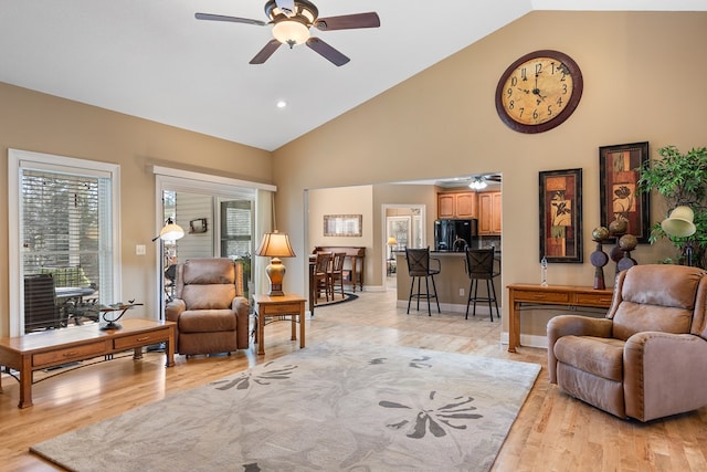 living area featuring high vaulted ceiling, ceiling fan, baseboards, and light wood-style floors