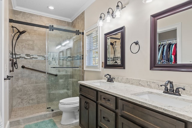 bathroom featuring ornamental molding, a stall shower, toilet, and a sink