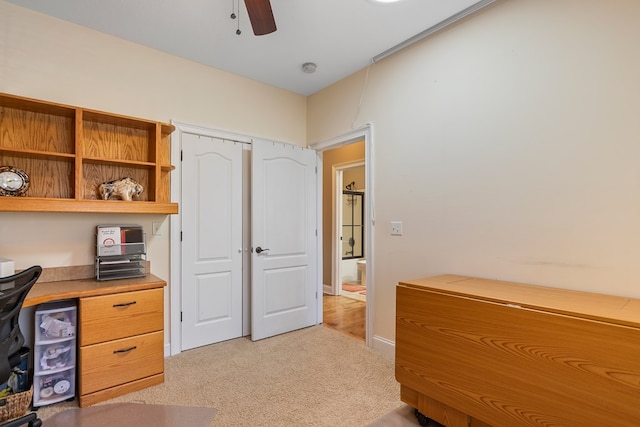 office space with a ceiling fan and light carpet