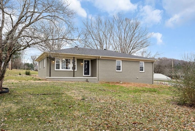 rear view of house featuring brick siding and a yard