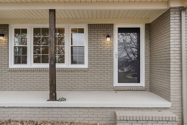 view of exterior entry featuring brick siding