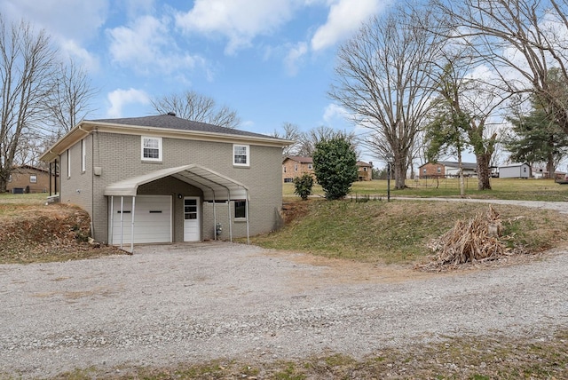 view of front of property featuring gravel driveway, brick siding, and an attached garage