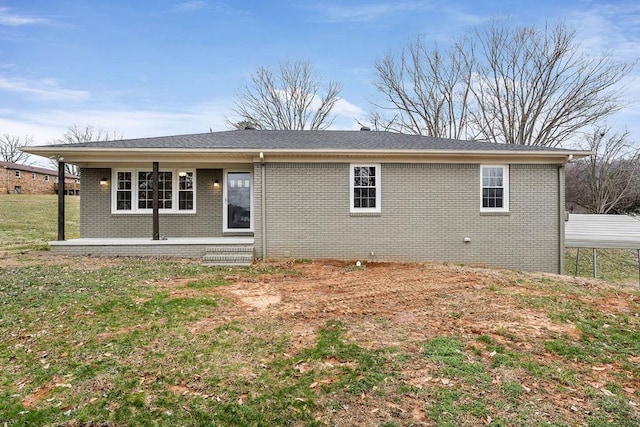 back of property featuring brick siding and a lawn