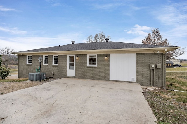 ranch-style house featuring central AC unit and brick siding