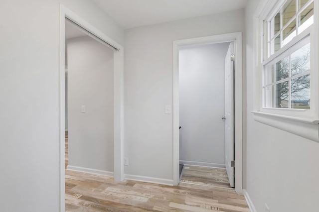 hall featuring light wood-style floors and baseboards