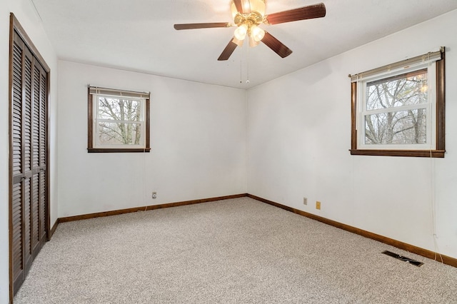 unfurnished bedroom with light colored carpet, a closet, visible vents, and multiple windows