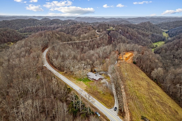 birds eye view of property featuring a mountain view and a view of trees