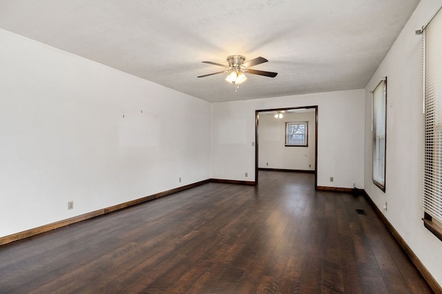 unfurnished room with ceiling fan, baseboards, dark wood finished floors, and a textured ceiling