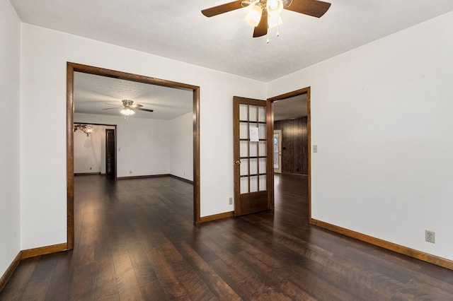 unfurnished room with dark wood-style flooring, a textured ceiling, and baseboards